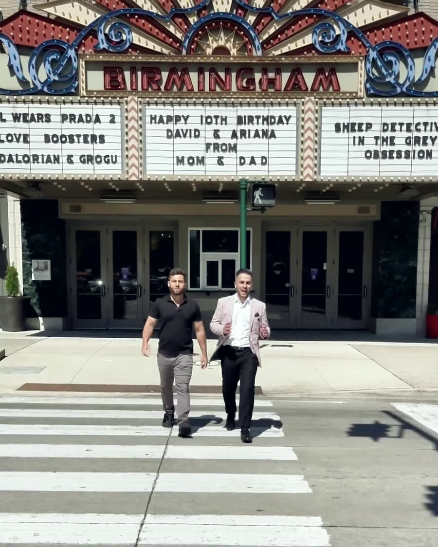 Joseph Jazrawi and Fanar Ayar walking past the Birmingham Theatre marquee on Woodward Avenue.