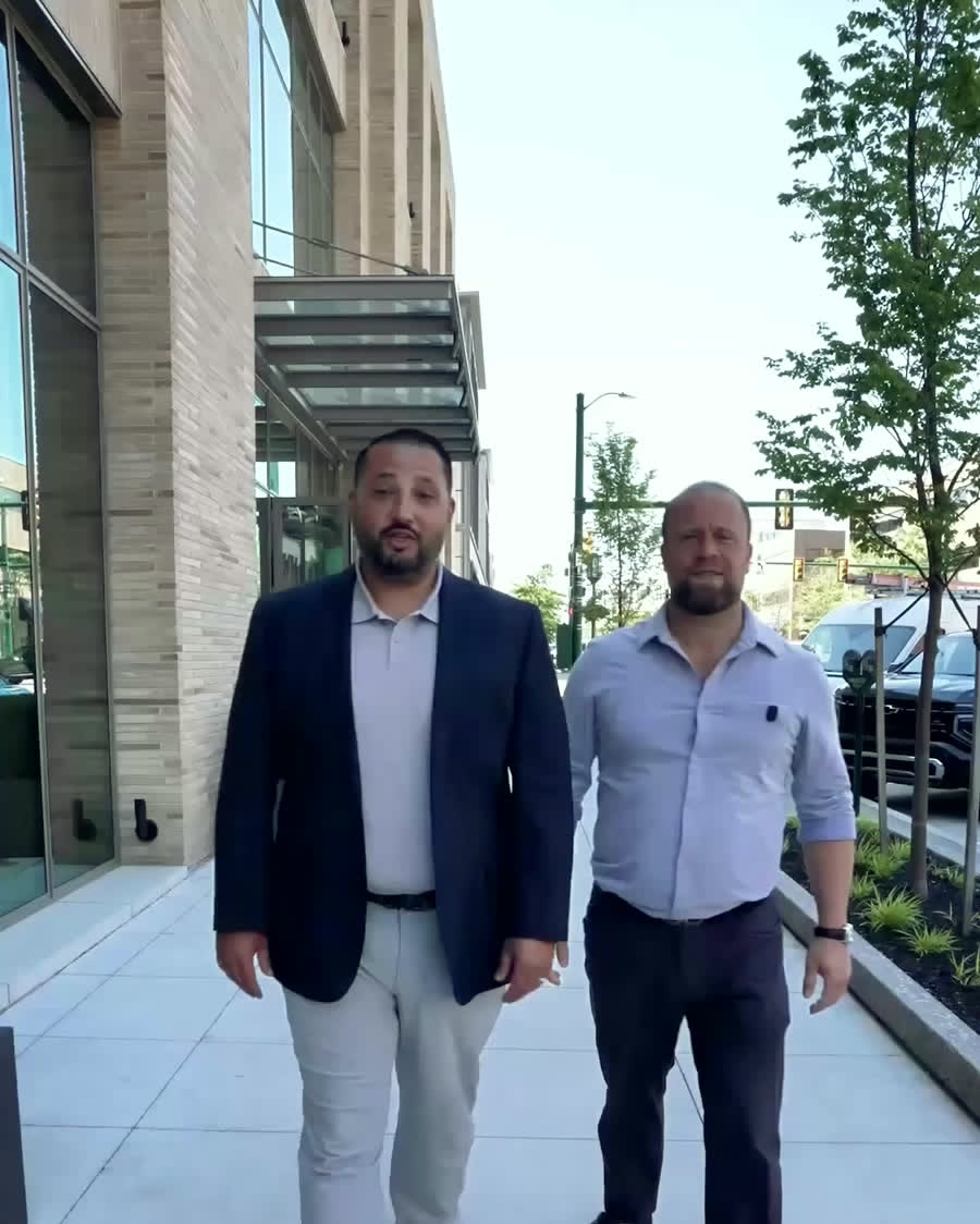 Jerry Nahhas and Dylan Jajo walking a commercial block in downtown Birmingham, Michigan.